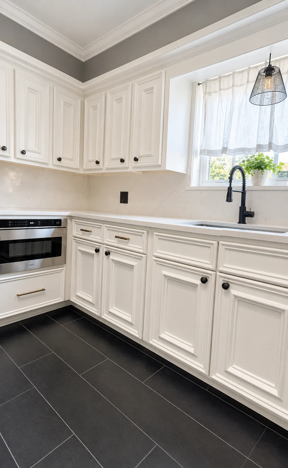 Renovated white kitchen with black faucet, stone backsplash and dark tile floors