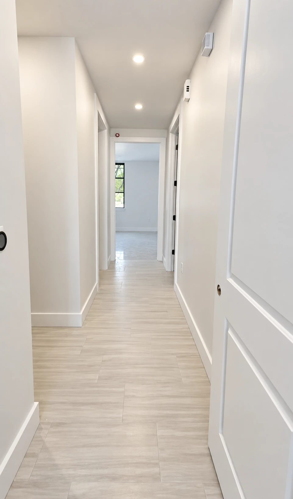 Bright renovated hallway in the Katy doctor’s office, with light tile floors and white doors